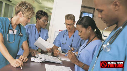 group of healthcare professionals standing around a desk or table